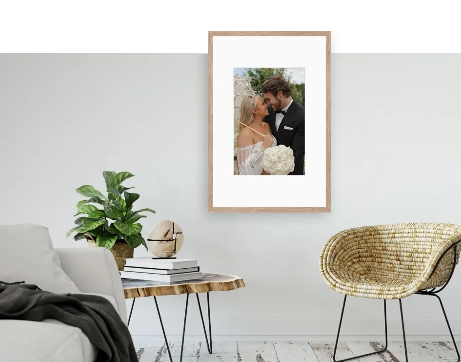 Framed wedding portrait hanging on wall in modern living room with minimalist decor.