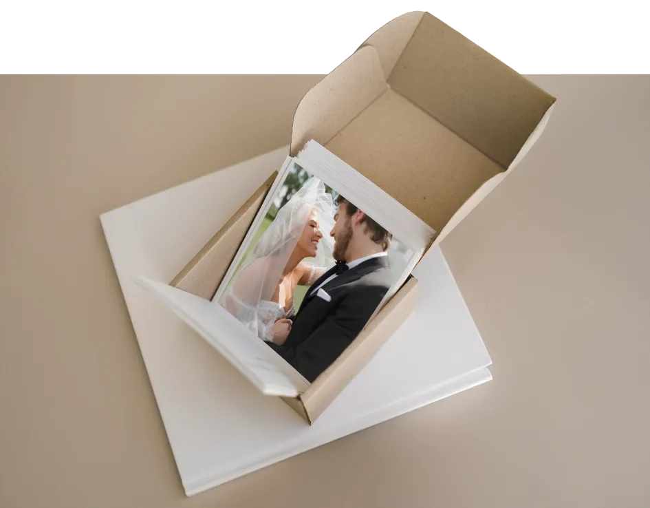 Open cardboard box with printed wedding photos neatly stacked inside shipped automatically from partnered printer.